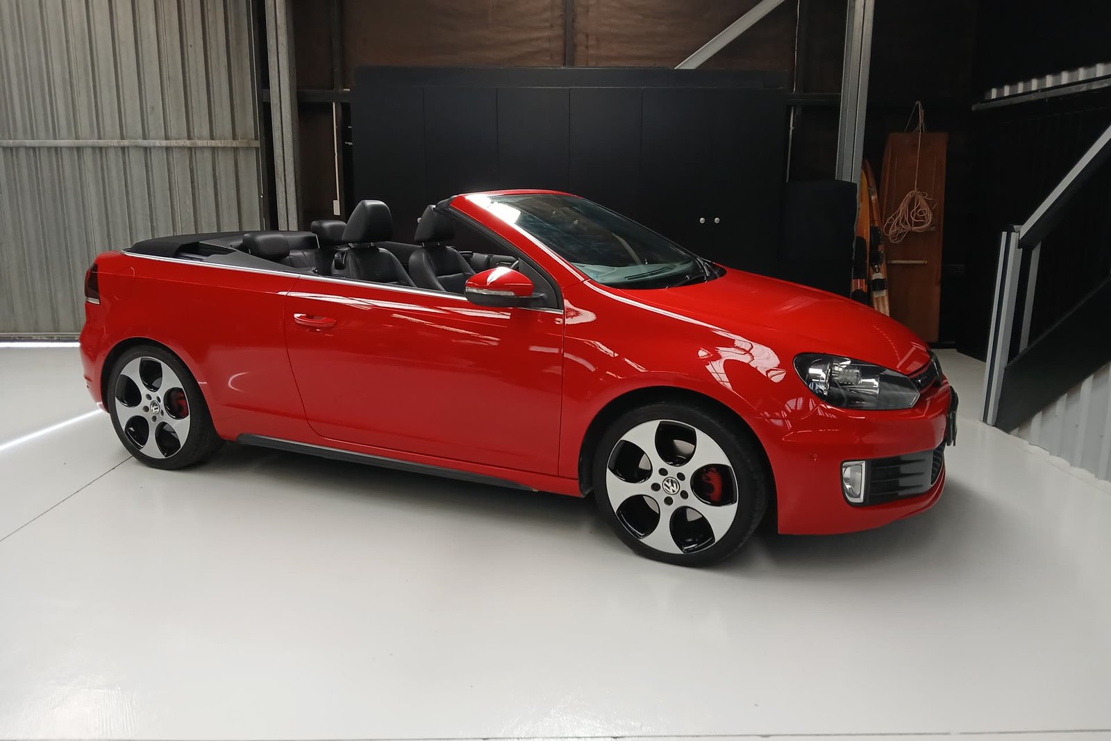 Red 2014 Golf GTI Cabrio, roof down, front three-quarter view in the workshop