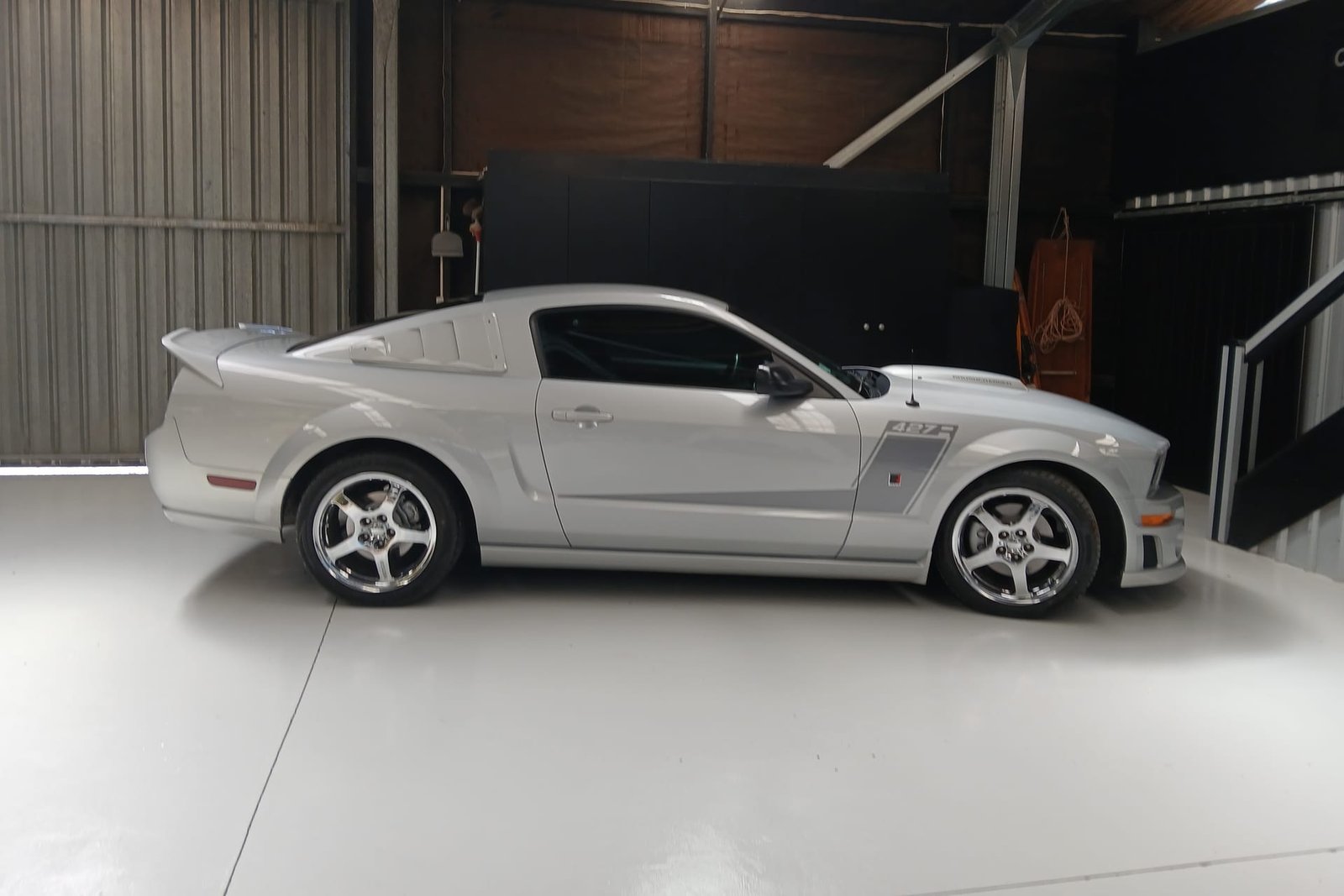Side view of the silver 2007 427R Roush Mustang in the workshop