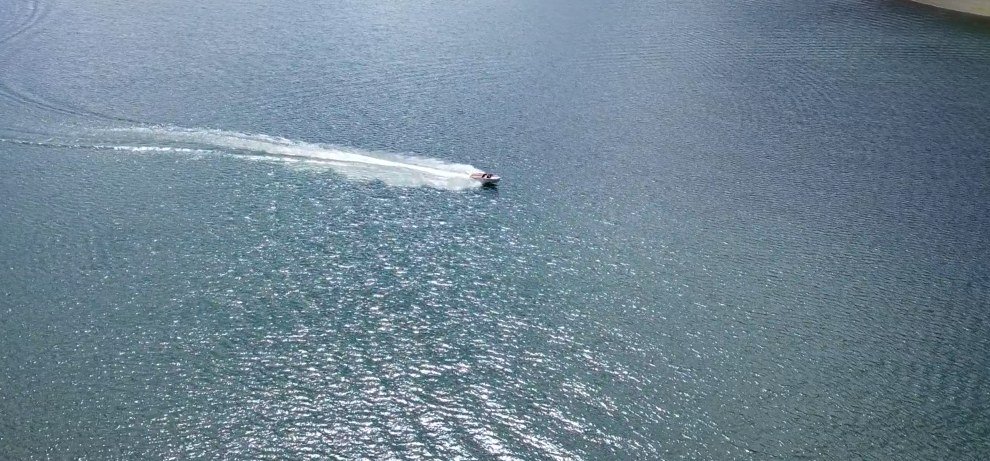 Ruby, the classic boat, running across the lake from above